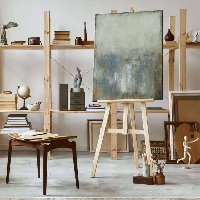 Woman's art studio with creative workspace, paintbrushes, and natural light — representing creativity and self-expression in midlife reinvention.
